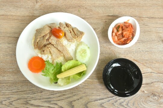 fried slice pork with teriyaki sauce and salad with kimchi tpping plain rice on plate