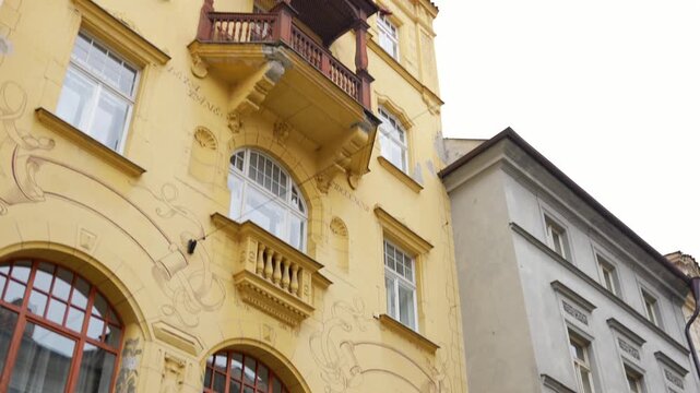 A historic Art Nouveau facade features sgraffito ornaments and elegant balconies on a winter day.