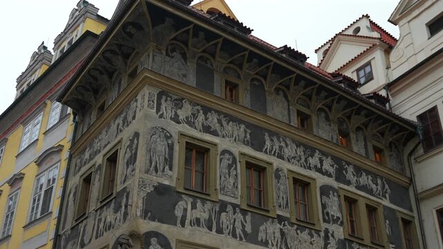An upward view of the House at the Stone Bell reveals medieval sgraffito decorations and ornate Gothic facade details.