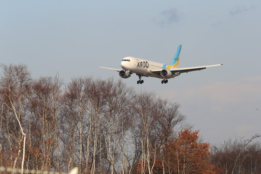 A commercial airliner on approach to New Chitose Airport against a blue sky on November 29, 2017 in New Chitose, Japan.