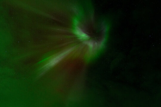 Abstract aurora borealis with green and red light in starry sky