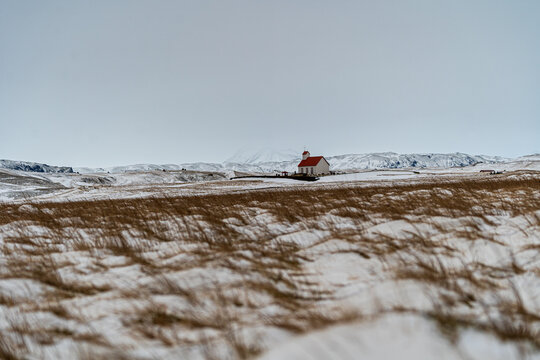 Historic White Church with Red Roof in a Snowy Icelandic Landscape