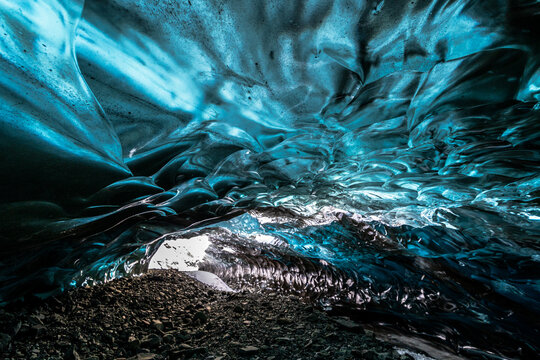Beautiful blue ice cave interior with skylight hole opening to the sky in Vatnaj&ouml;kull National Park, Iceland
