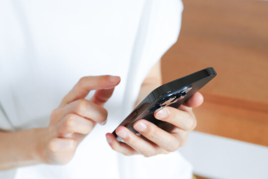 スマートフォンを操作する女性の手元