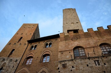 Fototapeta premium San Gimignano, Italy 03.04.2020: Town Hall (also known as the Palazzo del Popolo or Palazzo Nuovo del Podestà) and the Torre Grossa in San Gimignano