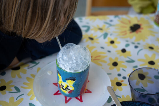 Foamy bubble milk in colorful mug with child