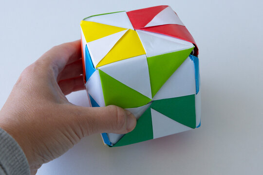 Child playing with colorful origami paper cube toy