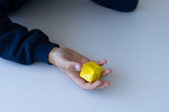 Child playing with colorful origami paper cube toy