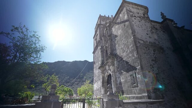 View the San Javier Mission church near Loreto highlighted by mountains and the surrounding desert oasis with clear skies above