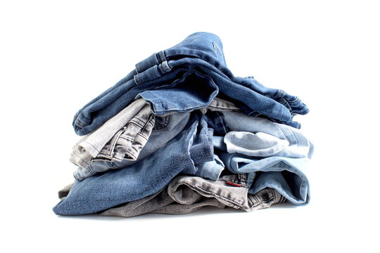 A pile of jeans lies on a white background.