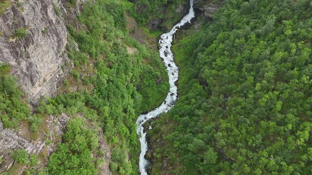 Aerial drone flyover of Dronning Sonjas stol waterfall and green cliffs, Norway