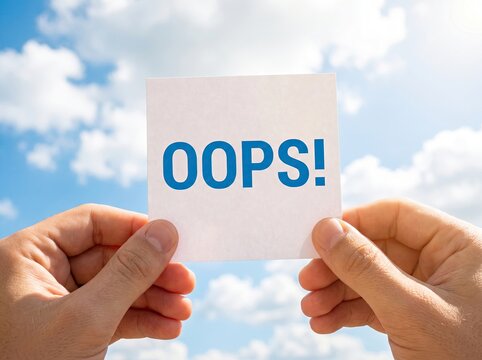 Hands holding a white card with oops text against a bright blue sky and fluffy white clouds