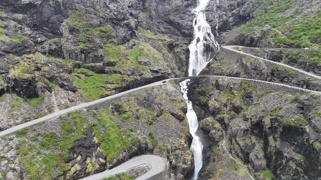 Aerial drone flyover of lower Trollstigen with winding road and Stigfossbrua, Norway