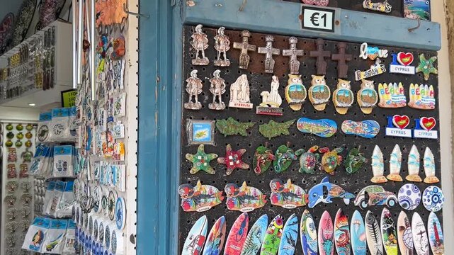 Cyprus, Larnaca, Souvenirs from Cyprus. A souvenir shop window with magnets. Memories of the island, various drawings