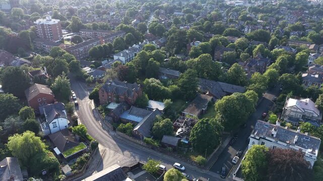 Aerial drone 4K footage showing streets and homes illuminated by warm golden hour sunlight England