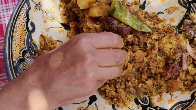 Eating traditional Moroccan trid with qaddid meat by hand

