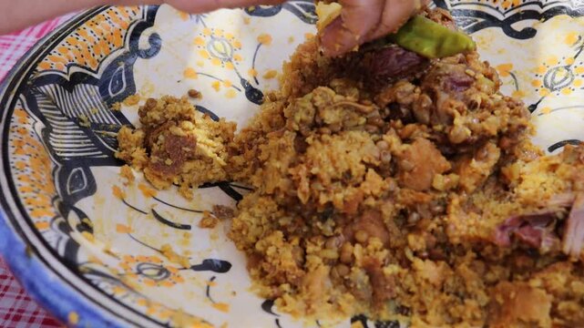 Eating traditional Moroccan trid with qaddid meat by hand
