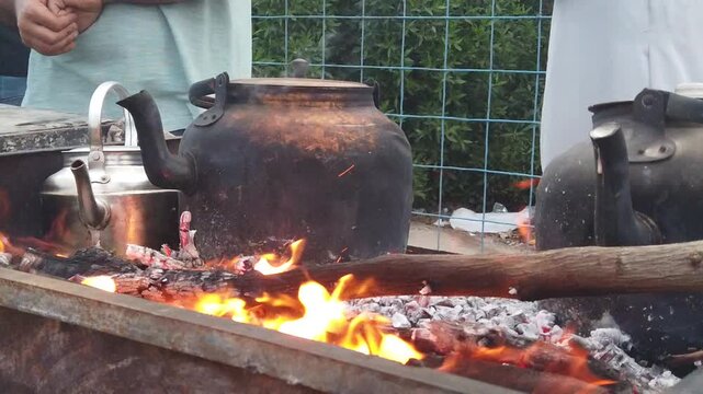 Traditional Metal Kettles Boiling Tea
Over Hot Wood Fire Flame in Karbala
