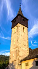 Obraz premium Historic stone church tower against clear blue sky.