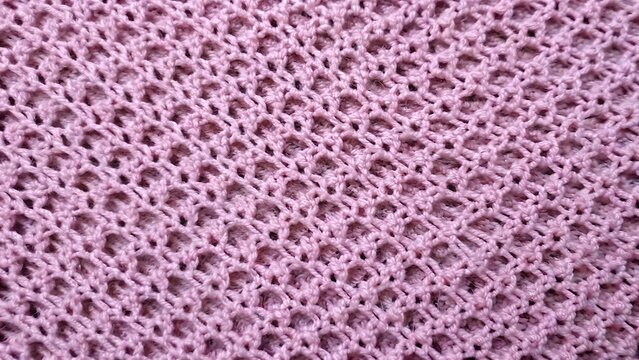 Pink knitted fabric texture with openwork mesh stitch pattern