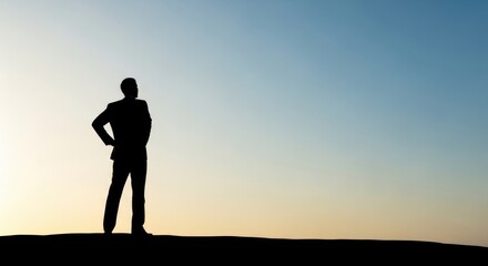 Fototapeta premium Silhouette of a person standing confidently against a serene twilight sky