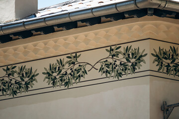 Decorative olive branch mural on the exterior wall of a Mediterranean villa in Cap d'Ail, France © Andrei Antipov