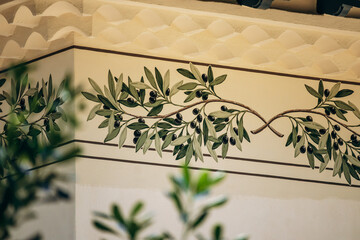 Decorative olive branch mural on the exterior wall of a Mediterranean villa in Cap d'Ail, France © Andrei Antipov