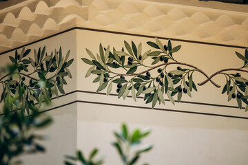 Decorative olive branch mural on the exterior wall of a Mediterranean villa in Cap d'Ail, France © Andrei Antipov