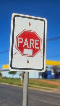 Brazilian traffic stop sign on a metal pole against a bright blue background