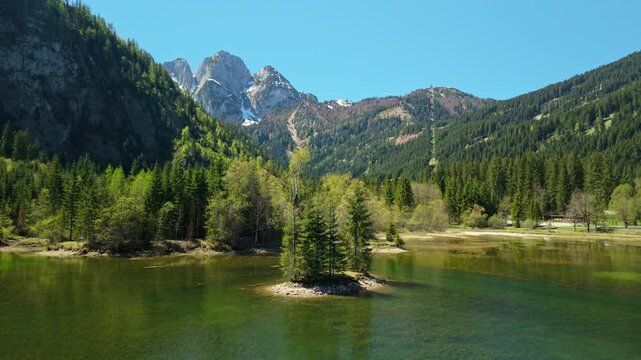 Aerial view of a tiny green island on Gosau mountain lake in Alps, Austria