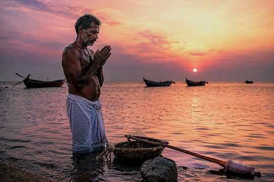 Traditional South Indian Pearl Diver Praying at Sunrise in Gulf of Mannar Waters with Fishing Boats Behind