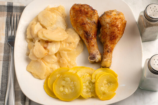 chicken drumsticks  with  a side of scolloped potates