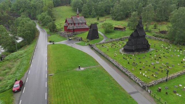 Aerial drone flyover of Borgund Stave Church with river background, Norway