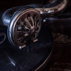 Macro close-up of a vintage gramophone soundbox and needle resting on a record. Antique analog music player with polished metal tonearm, showcasing early audio technology and craftsmanship. © Marek