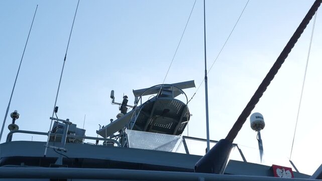 A close-up view of a satellite navigation system installed aboard a military ship, highlighting advanced maritime navigation technology used for precise positioning