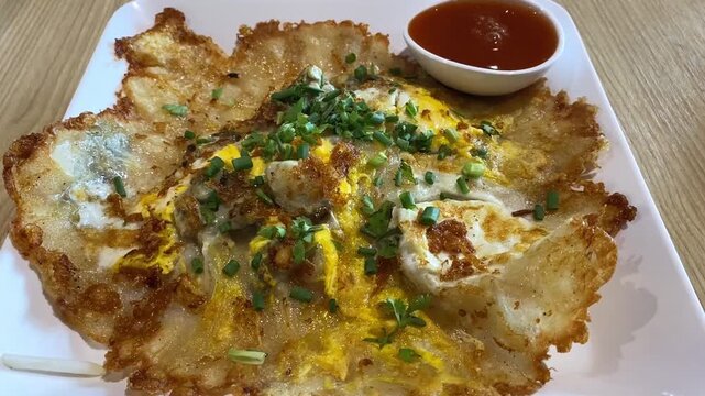 Traditional Thai Crispy Fried Clam Mussel Seafood Omelette Pancake (Hoy Tod) with Red Chili Dipping Sauce In Cast Iron Skillet Pan Served Cooked in Bangkok Asian Street Food Restaurant