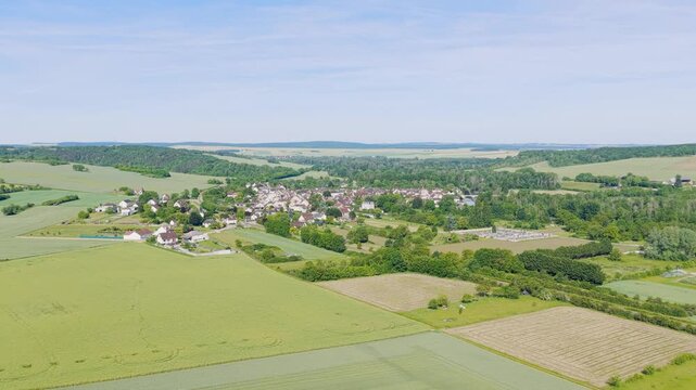 A high-resolution aerial drone shot showcasing the picturesque rural village of Accolay Deux Rivieres, located in Bourgogne-Franche-Comte, France. The video captures the village nestled among lush
