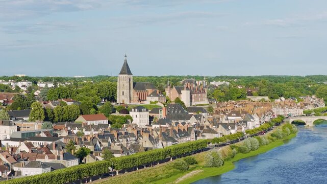 Aerial panoramic view of the historic town of Gien in the Centre-Val de Loire region of France, featuring traditional French architecture, the prominent Gien church, and the scenic Loire River with