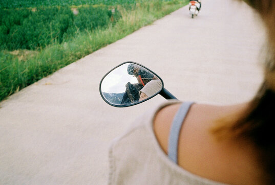 Scooter Rear-View Mirror Reflection on a Rural Road 
