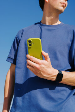 Man holding yellow smartphone outdoors lifestyle concept