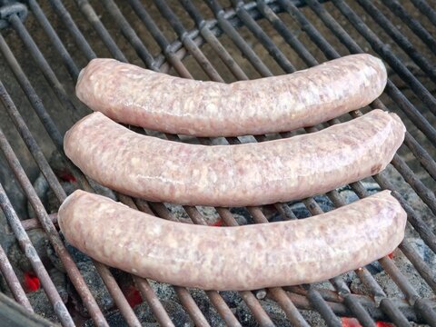 Rohe grobe Bratwurst auf einem Holzkohlegrill 