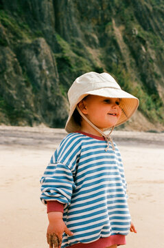 Toddler in striped shirt on beach film photo