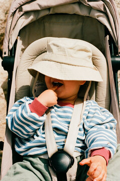 Child in striped shirt sitting in stroller film photo