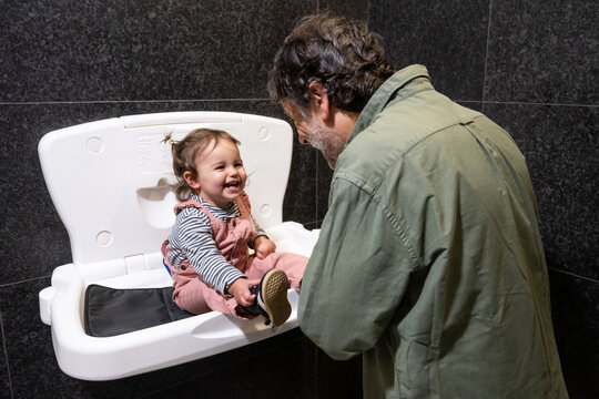 Happy Toddler During Diaper Change With Father In Restroom