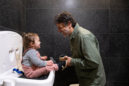 Happy Toddler During Diaper Change With Father In Restroom