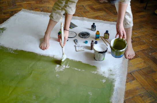 artist painting a white canvas green 
