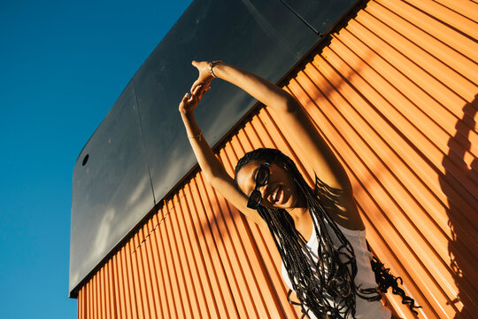 Young woman leaning on colorful urban structure