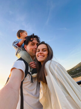 Family taking selfie outdoors at sunset