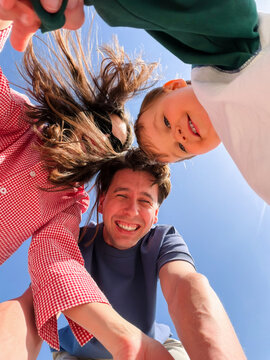 Happy family selfie outdoors under a blue sky