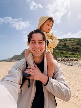 Father taking selfie with child on beach